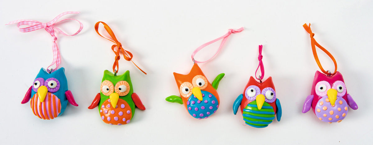 Five colourful handmade fimo polymer clay owl ornaments hanging from pink, orange, pink, green, and orange ribbons against a plain white background.