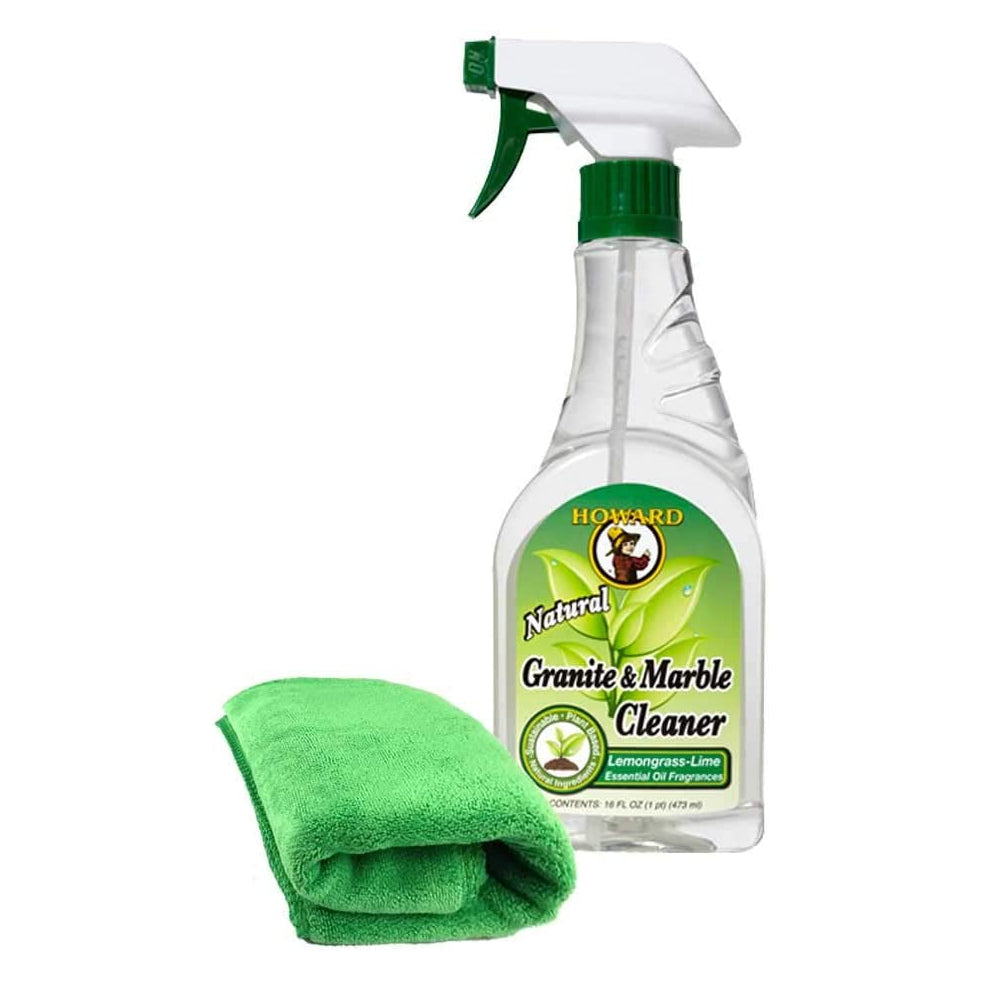Clear spray bottle labeled 'Howard Natural Granite & Marble Cleaner' with a green microfibre cloth on a white background