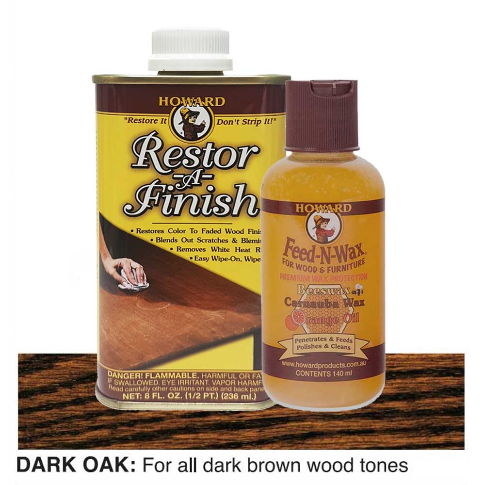 Two bottles of Howard Restor-A-Finish and Feed-N-Wax on a dark oak wooden surface.