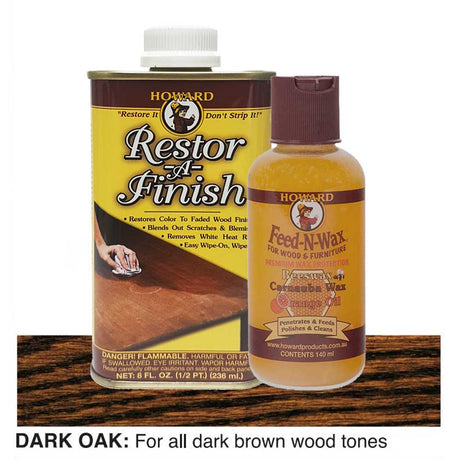 Two bottles of Howard Restor-A-Finish and Feed-N-Wax on a dark oak wooden surface.
