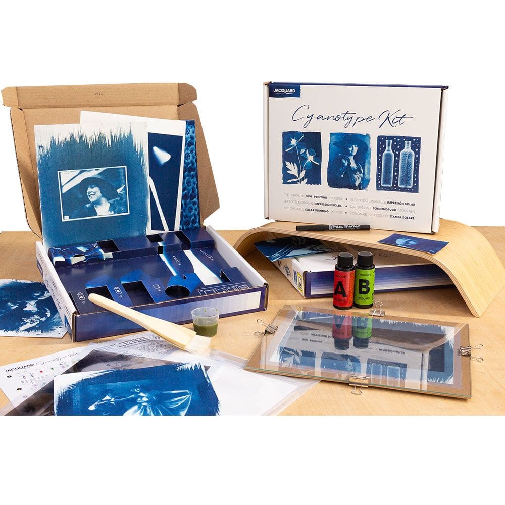 Cyanotype kit with photos and supplies on a wooden surface