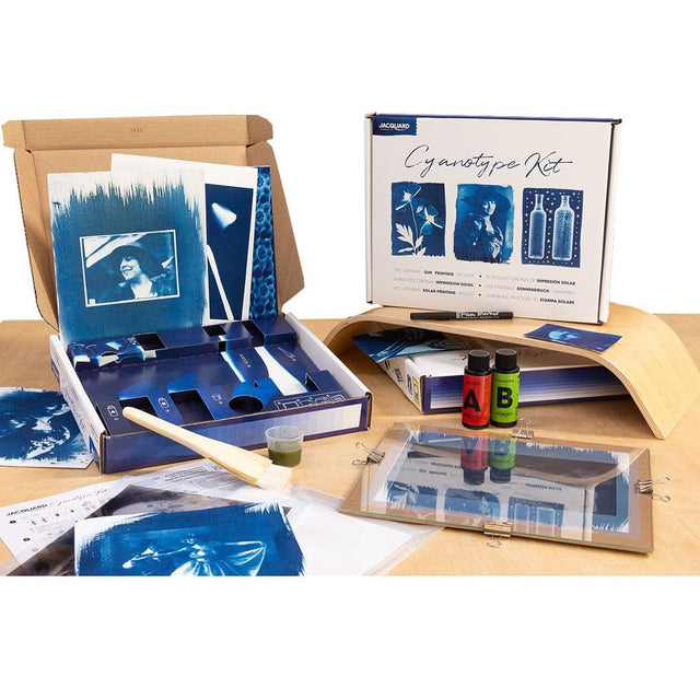 Cyanotype kit with photos and supplies on a wooden surface