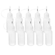 Ten small translucent white squeeze bottles with metal tips for fine application of paint on a white background