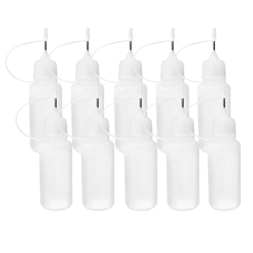 Ten small translucent white squeeze bottles with metal tips for fine application of paint on a white background