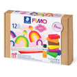 FIMO Soft Basic clay kit in a brown kraft paper box with a white front label showing rainbow and stacked clay pieces, plus a small bottle of adhesive and tools.