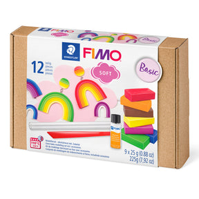 FIMO Soft Basic clay kit in a brown kraft paper box with a white front label showing rainbow and stacked clay pieces, plus a small bottle of adhesive and tools.