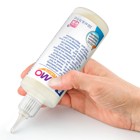 Hand holding a bottle of fimo liquid on a white background