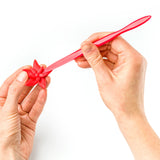 Red plastic tool held by two hands modelling fimo clay