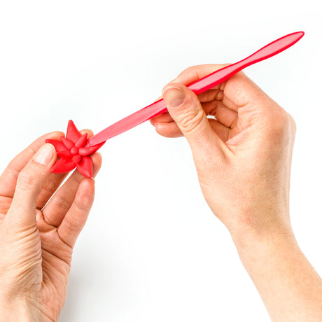 Red plastic tool held by two hands modelling fimo clay