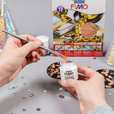 fimo glue being applied to fimo with gold leaf