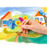 Hand holding a paintbrush over a colorful watercolor painting of a landscape with houses and flowers.
