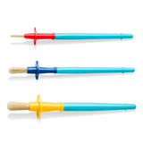 Three paintbrushes arranged horizontally on a white background, each with a different colored handle end (red, blue, yellow) and a turquoise plastic shaft.