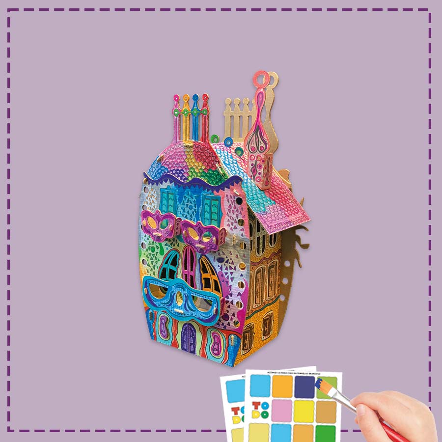 Colorful 3D house craft kit with a hand holding a color swatch on a purple background