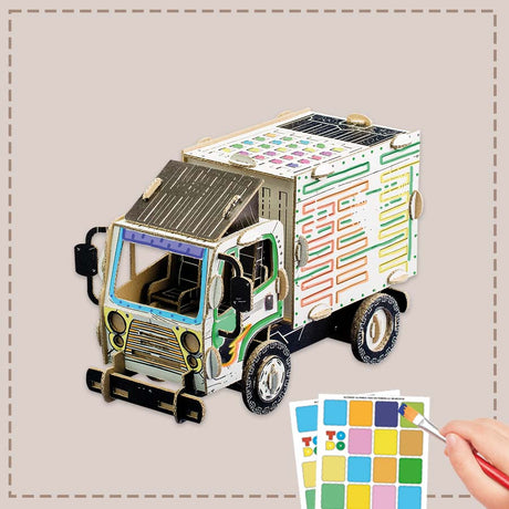 3d cardboard truck with a hand holding a paintbrush and color swatches on a neutral background